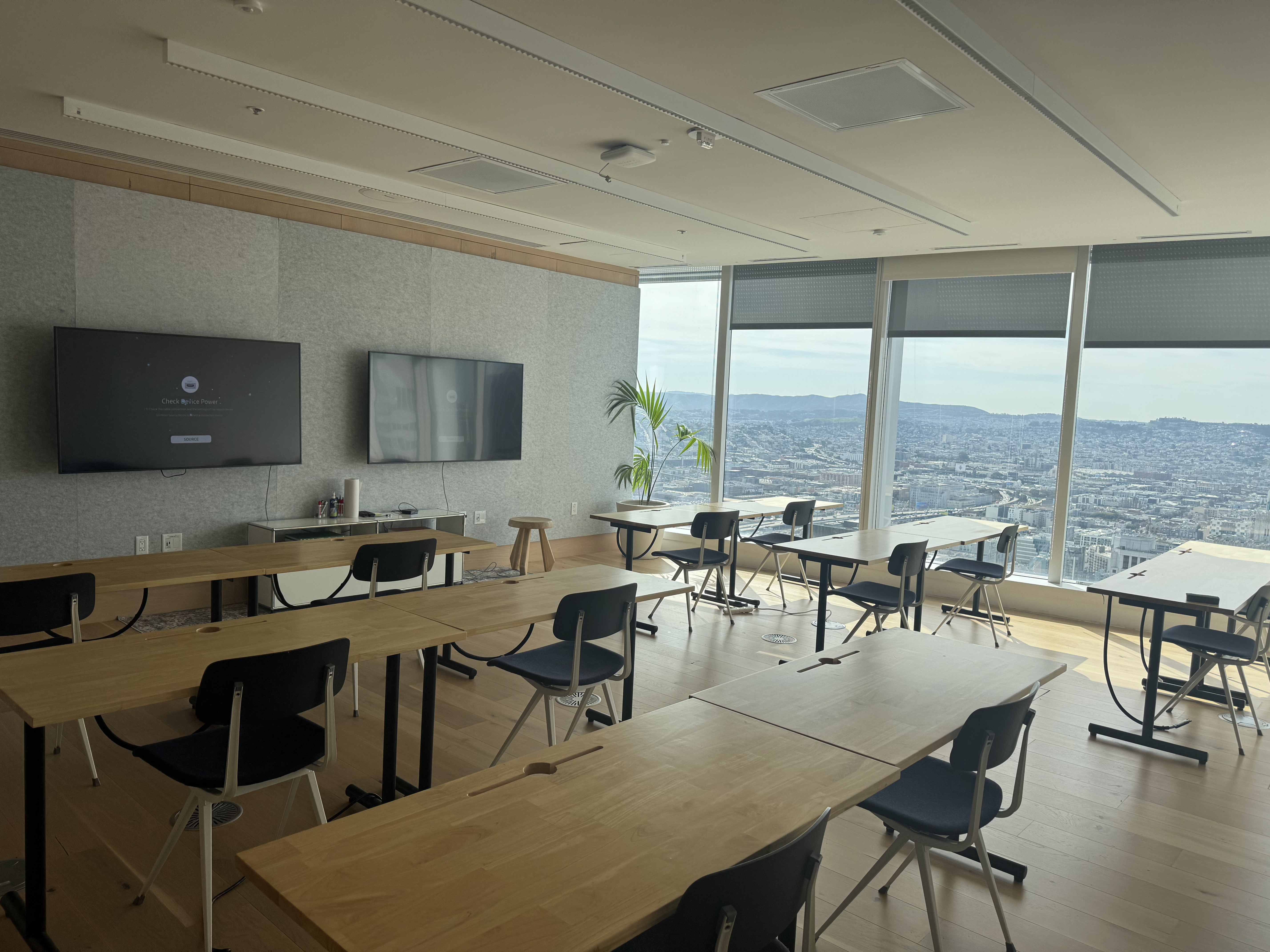 Classroom with tables, screens, and a city view